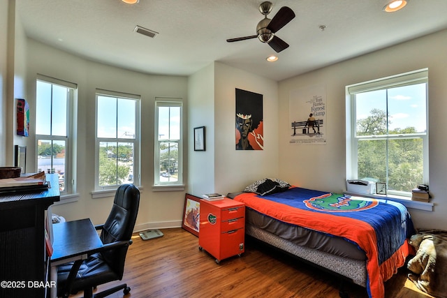 bedroom with dark hardwood / wood-style floors and ceiling fan