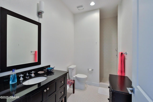 bathroom featuring tiled shower, tile patterned floors, toilet, and vanity