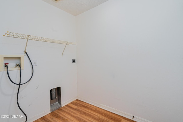 clothes washing area with washer hookup, a textured ceiling, hardwood / wood-style flooring, and electric dryer hookup