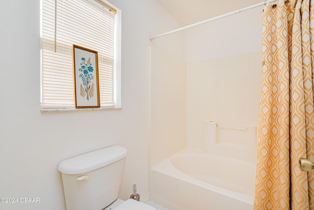 bathroom with toilet, a healthy amount of sunlight, and shower / tub combo with curtain