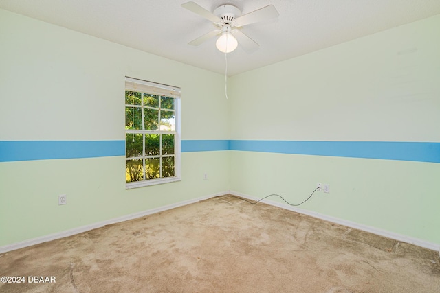 carpeted spare room featuring ceiling fan