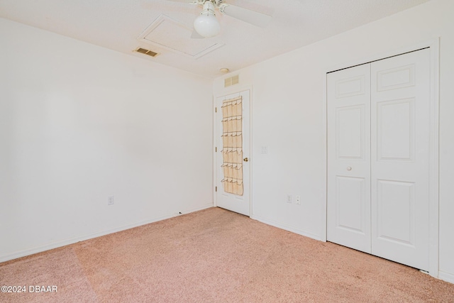 unfurnished bedroom with ceiling fan, light colored carpet, and a closet