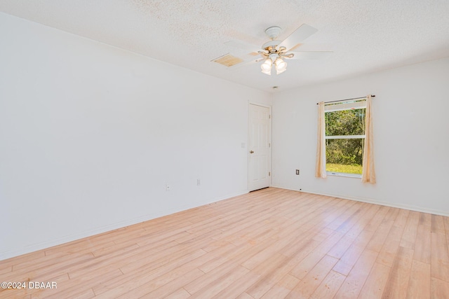 empty room featuring ceiling fan, light hardwood / wood-style flooring, and a textured ceiling