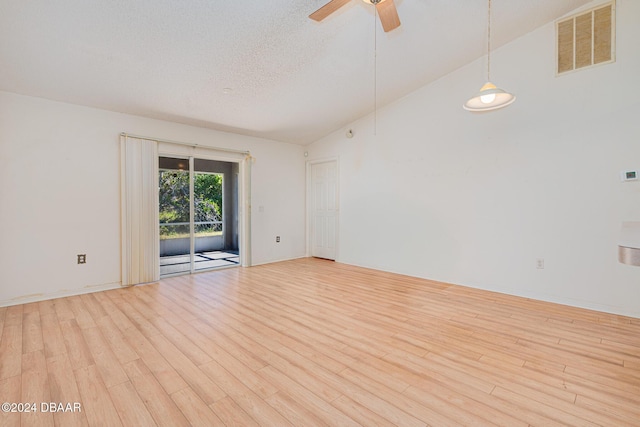 spare room with a textured ceiling, high vaulted ceiling, light hardwood / wood-style flooring, and ceiling fan