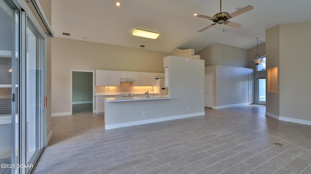 51 Bay Pointe Dr, Ormond Beach, FL 32174 - kitchen featuring a towering ceiling, ceiling fan with notable chandelier, sink, white fridge with ice dispenser, and light hardwood / wood-style flooring