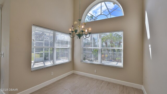 51 Bay Pointe Dr, Ormond Beach, FL 32174 - unfurnished dining area with a notable chandelier, a healthy amount of sunlight, and light wood-type flooring