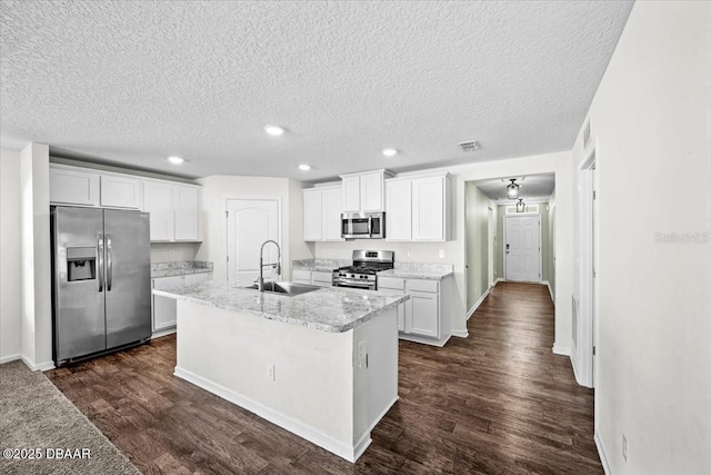 20 Sand Wedge Ln, Bunnell, FL 32110 - kitchen with stainless steel appliances, a sink, white cabinets, dark wood-type flooring, and a kitchen island with sink