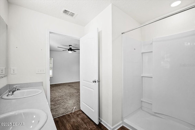 20 Sand Wedge Ln, Bunnell, FL 32110 - full bath with wood finished floors, a shower, a textured ceiling, ceiling fan, and double vanity