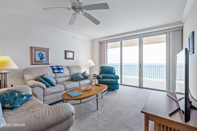 carpeted living area with crown molding and ceiling fan