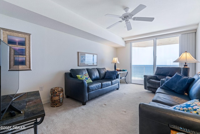 living area featuring carpet, ceiling fan, and baseboards