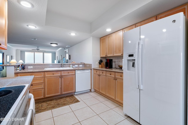 kitchen featuring white appliances, a sink, ceiling fan, light countertops, and light tile patterned floors