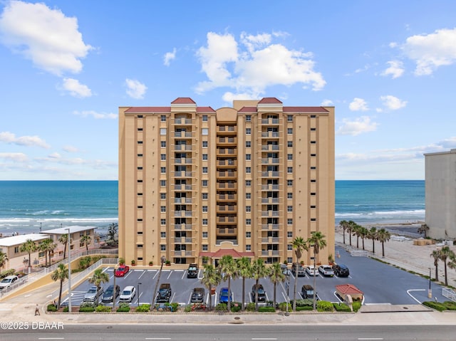 view of apartment building / complex featuring view of water and beach
