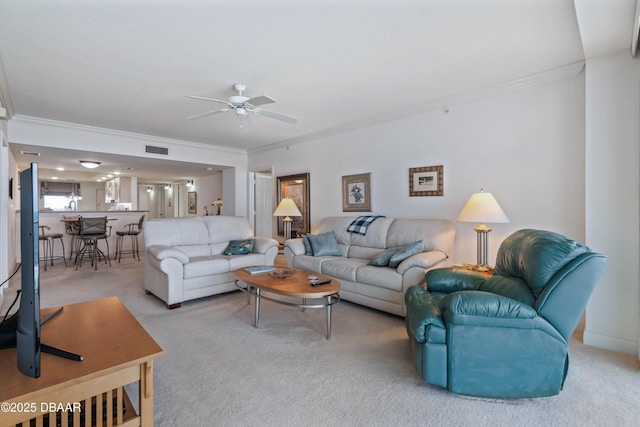 living room featuring crown molding, carpet, and a ceiling fan