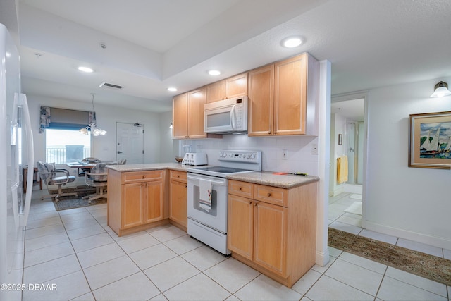 kitchen featuring white appliances, a peninsula, light countertops, recessed lighting, and light tile patterned flooring