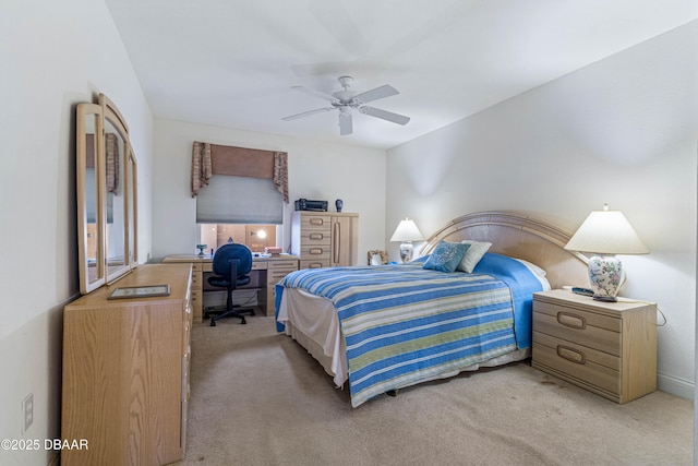 bedroom with light carpet, a desk, and a ceiling fan