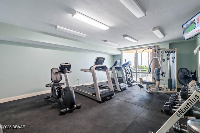 workout area with a textured ceiling and baseboards