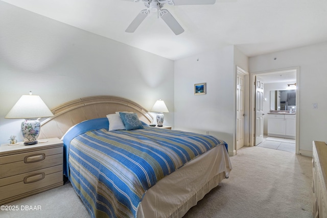 bedroom with light colored carpet, connected bathroom, baseboards, and ceiling fan