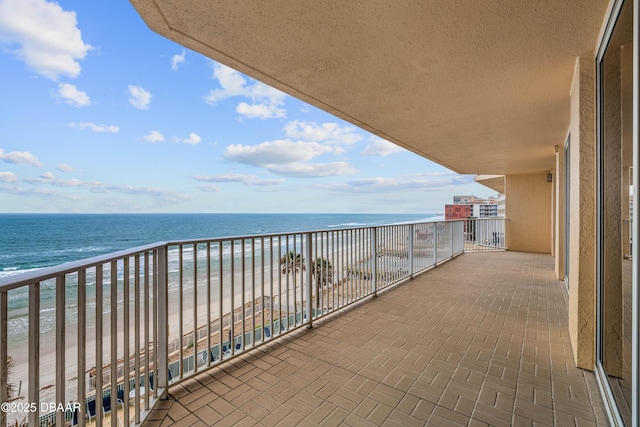 balcony with view of water and beach