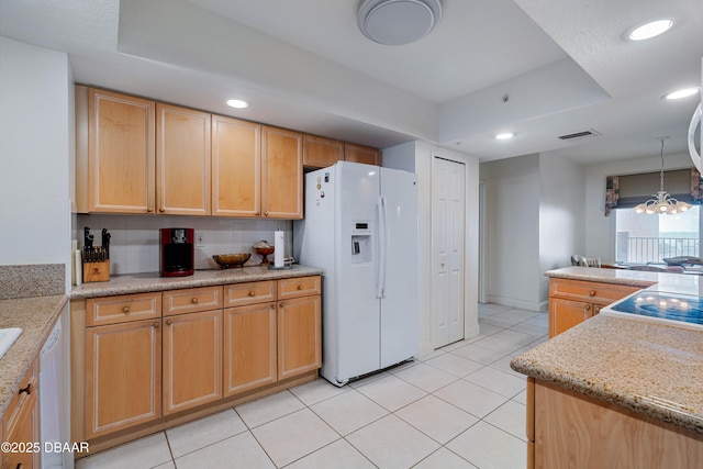 kitchen with white appliances, a raised ceiling, light tile patterned floors, recessed lighting, and decorative light fixtures