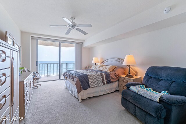 bedroom with light carpet, access to exterior, a water view, and ceiling fan