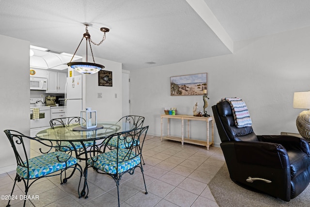 dining area with a textured ceiling and light tile patterned floors