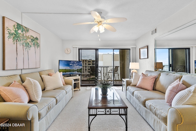 carpeted living room with ceiling fan and a textured ceiling