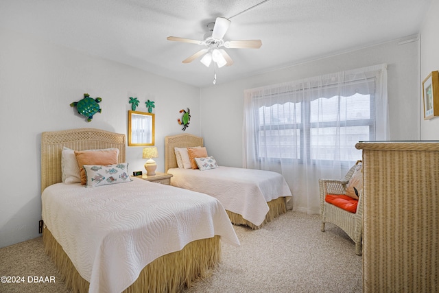 bedroom featuring ceiling fan, a textured ceiling, and carpet floors