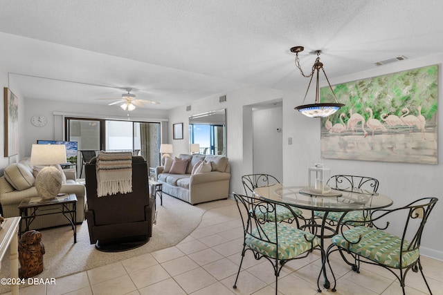 tiled dining room featuring a textured ceiling and ceiling fan