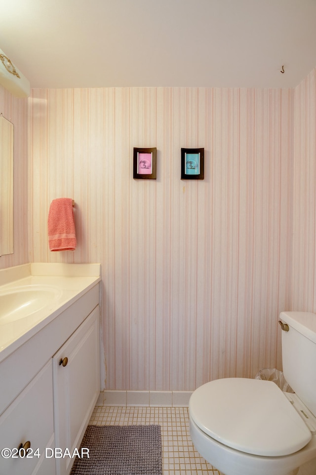 bathroom with toilet, vanity, and tile patterned flooring