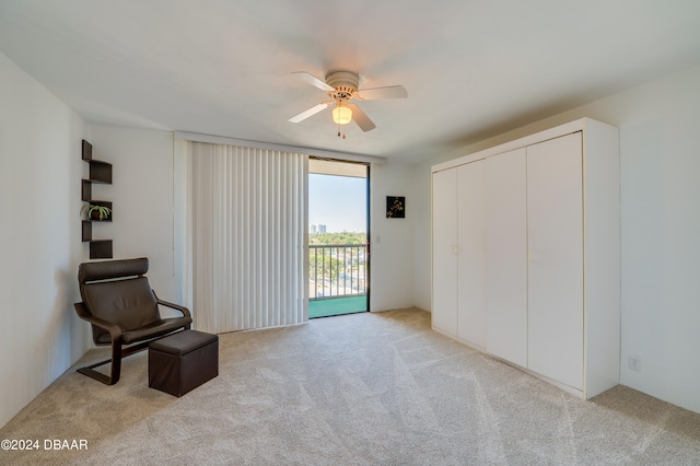 living area featuring light carpet and ceiling fan