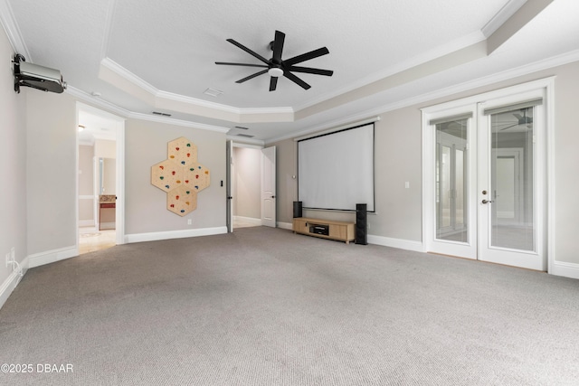 46 Audubon Ln, Flagler Beach, FL 32136 - unfurnished living room featuring a raised ceiling, crown molding, ceiling fan, carpet flooring, and french doors