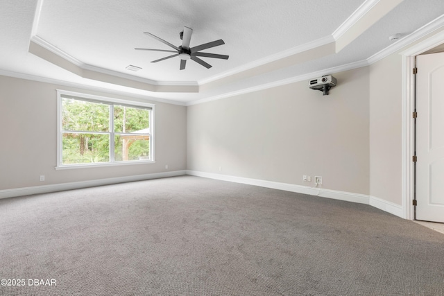 46 Audubon Ln, Flagler Beach, FL 32136 - spare room featuring a raised ceiling, ceiling fan, crown molding, carpet flooring, and baseboards