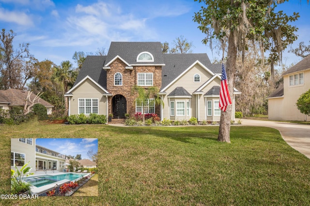 46 Audubon Ln, Flagler Beach, FL 32136 - traditional-style home with a front yard, a shingled roof, and stone siding