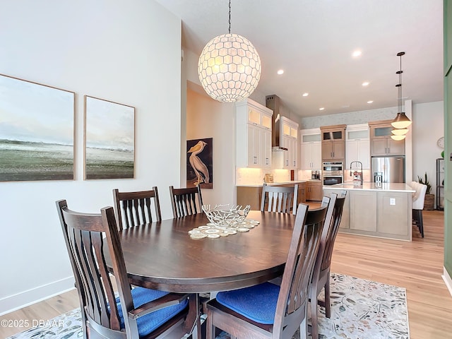 dining space with light wood-type flooring, baseboards, and recessed lighting