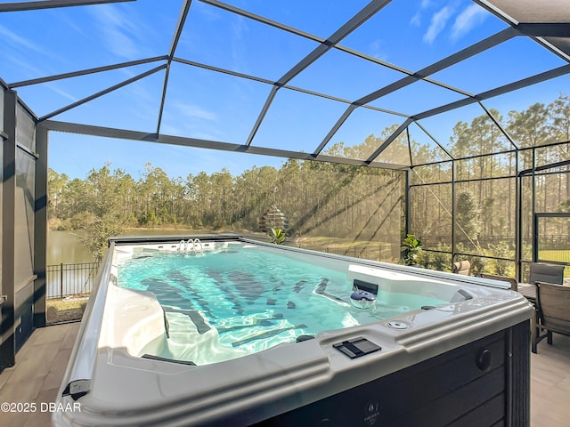 view of swimming pool featuring glass enclosure, a patio area, and a hot tub