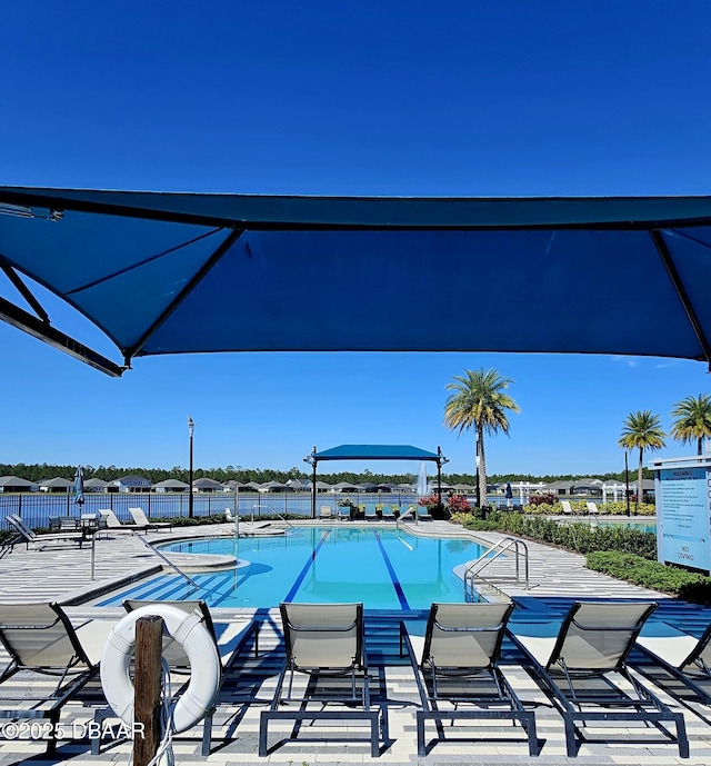 community pool with a patio area and fence