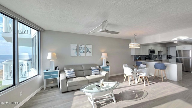 1133 Ocean Shore Blvd Unit 506, Ormond Beach, FL 32176 - living area featuring plenty of natural light, light wood finished floors, and a textured ceiling