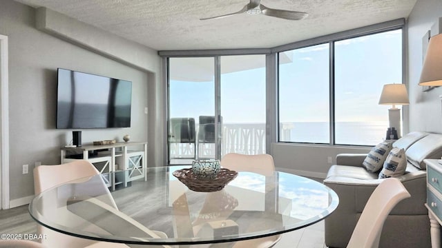 1133 Ocean Shore Blvd Unit 506, Ormond Beach, FL 32176 - dining space with a textured ceiling, wood finished floors, ceiling fan, and a water view