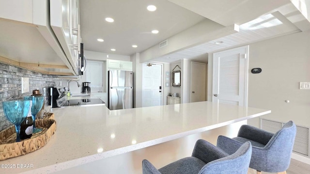 1133 Ocean Shore Blvd Unit 506, Ormond Beach, FL 32176 - kitchen featuring freestanding refrigerator, a peninsula, a breakfast bar, recessed lighting, and range
