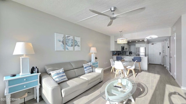 1133 Ocean Shore Blvd Unit 506, Ormond Beach, FL 32176 - living room featuring ceiling fan, a textured ceiling, and light wood-style flooring