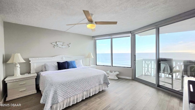 1133 Ocean Shore Blvd Unit 506, Ormond Beach, FL 32176 - bedroom featuring access to exterior, a textured ceiling, wood finished floors, and a ceiling fan