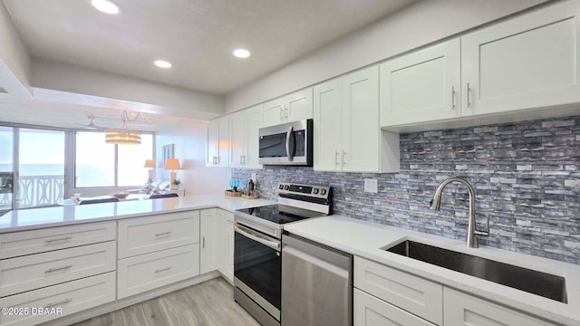 1133 Ocean Shore Blvd Unit 506, Ormond Beach, FL 32176 - kitchen with appliances with stainless steel finishes, light countertops, white cabinetry, decorative backsplash, and recessed lighting