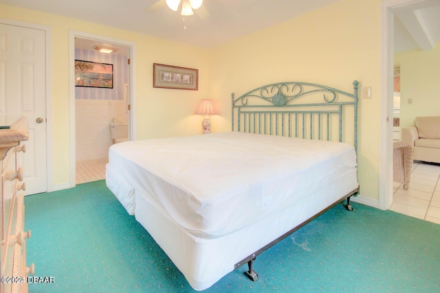 bedroom with tile patterned flooring, ensuite bathroom, and ceiling fan