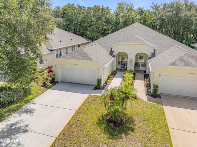 3017 Glin Cir, Ormond Beach, FL 32174 - view of front of home featuring a shingled roof, an attached garage, concrete driveway, stucco siding, and a front yard
