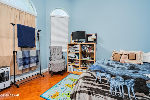 bedroom with hardwood / wood-style flooring and heating unit