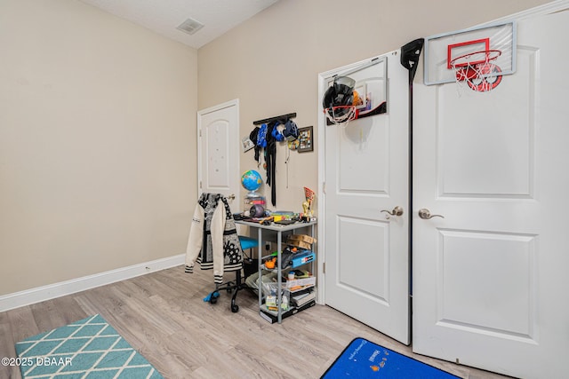 playroom featuring light wood-type flooring and a textured ceiling