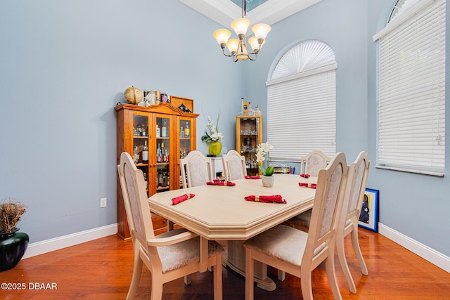 dining room with wood-type flooring and an inviting chandelier