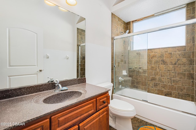 full bathroom with shower / bath combination with glass door, tile patterned floors, vanity, and toilet