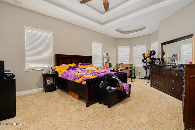 bedroom featuring ceiling fan, a raised ceiling, light colored carpet, and ornamental molding