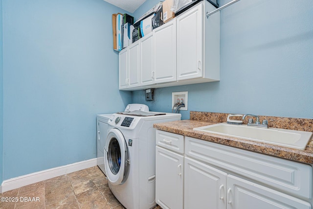 washroom with cabinets, washing machine and dryer, and sink